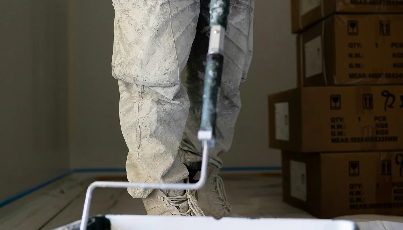 Artisan peintre en bâtiment appliquant une peinture blanche au rouleau sur un chantier de rénovation en Seine-et-Marne